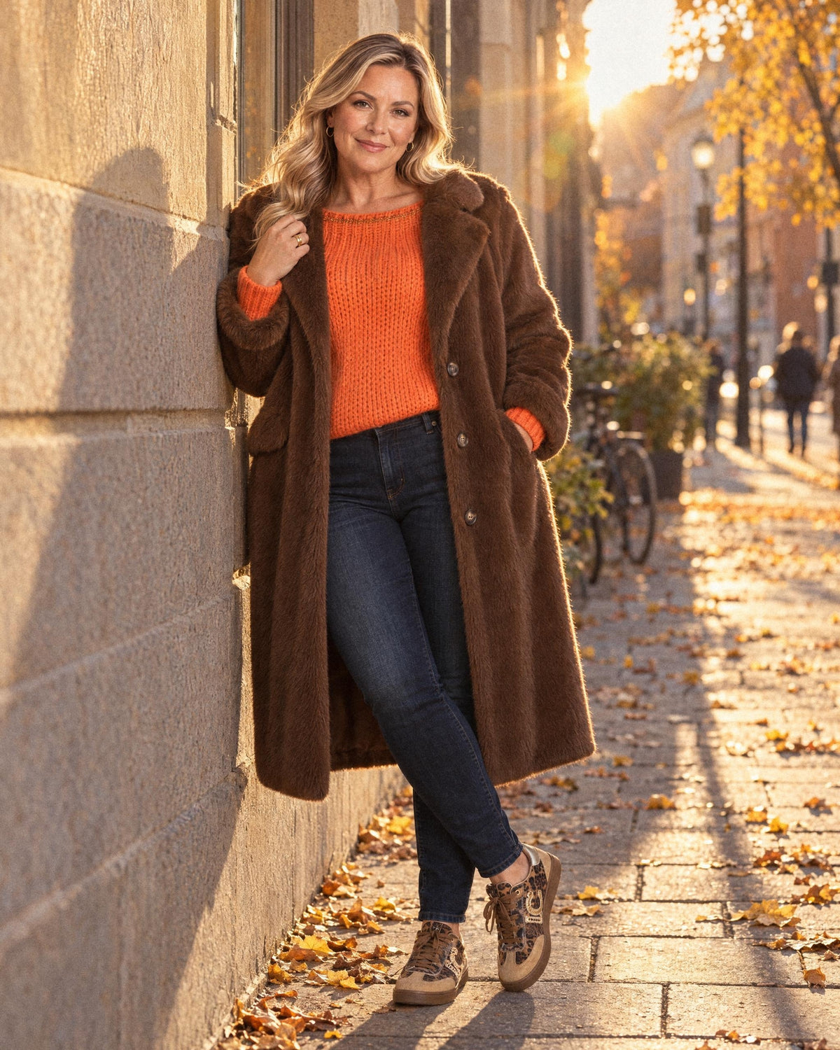 Höstlook med brun fuskpälskappa och orange stickad tröja